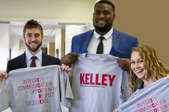 Three students hold up I-Core Program t-shirts.